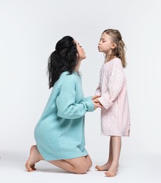 Photo of Beautiful mother with little daughter on white background