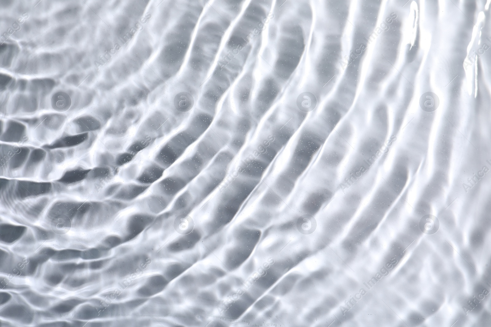 Photo of Closeup view of water with rippled surface on light background