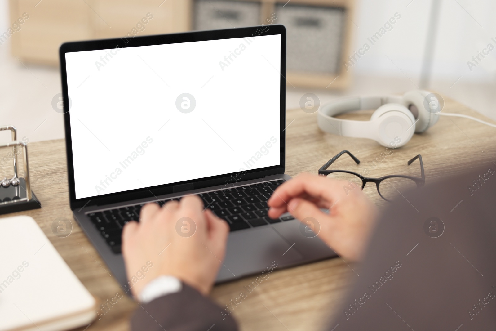 Photo of Man watching webinar at wooden table in office, closeup