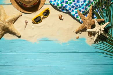 Flat lay composition with beach objects, sand and space for text on wooden background