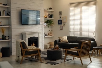 Photo of Cozy living room interior with comfortable sofa, armchairs and decorative fireplace