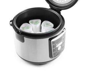 Photo of Open multi cooker with cups of homemade yogurt isolated on white