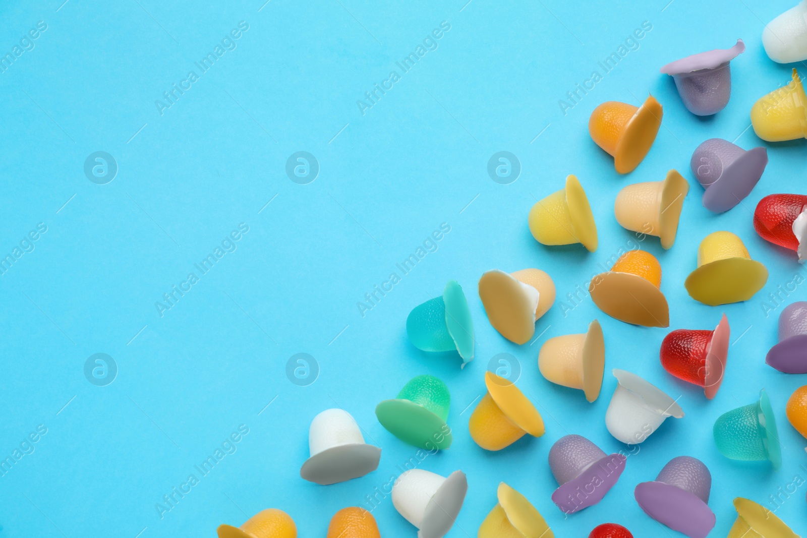 Photo of Tasty bright jelly cups on light blue background, flat lay. Space for text