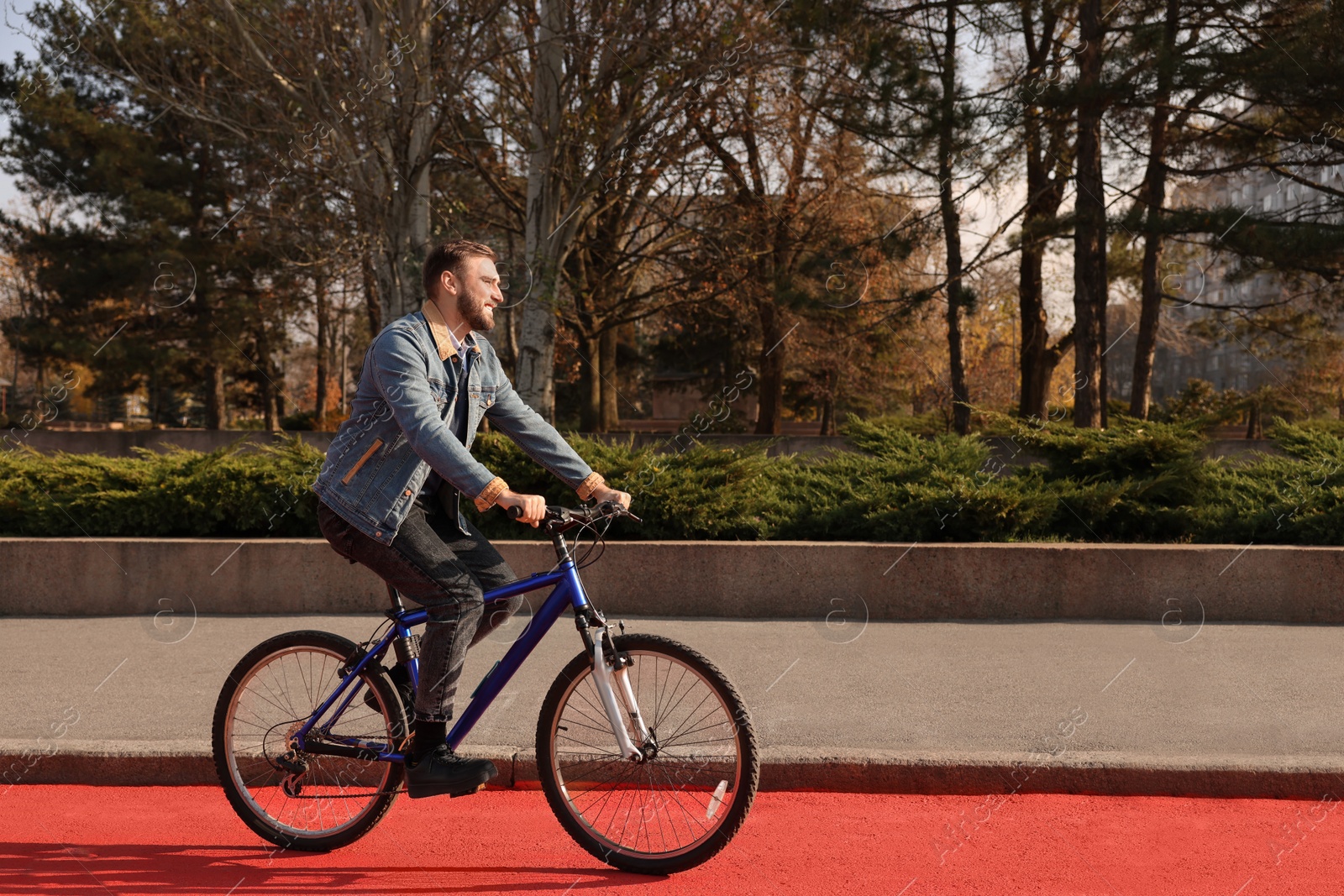 Photo of Happy handsome man riding bicycle on lane in city