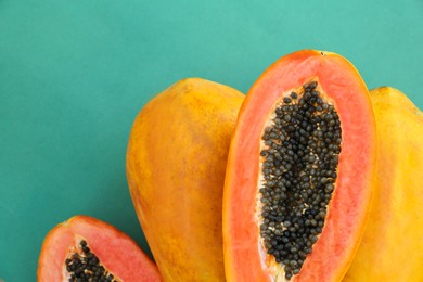 Photo of Fresh ripe cut and whole papaya fruits on light blue background, flat lay