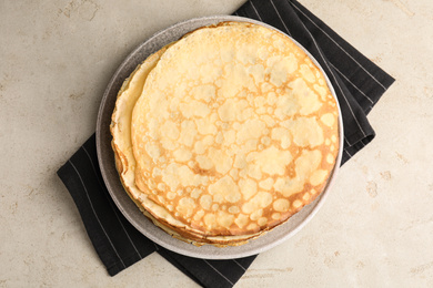 Photo of Stack of fresh thin pancakes on light grey table, top view