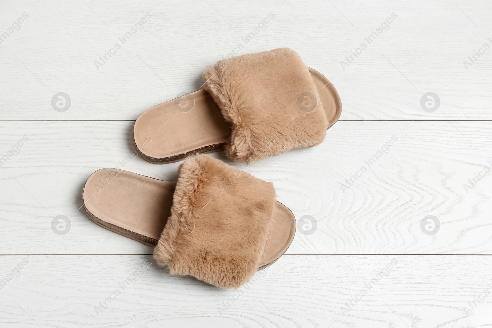 Photo of Pair of soft slippers on white wooden background, flat lay