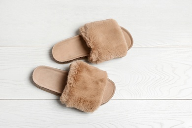 Photo of Pair of soft slippers on white wooden background, flat lay