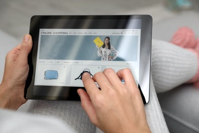 Photo of Woman using tablet for online shopping indoors, closeup