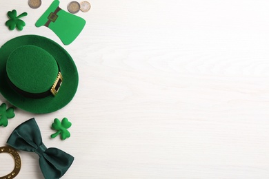 Photo of Flat lay composition with leprechaun hat on white wooden table, space for text. St Patrick's Day celebration