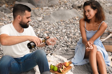 Happy young couple having picnic on beach