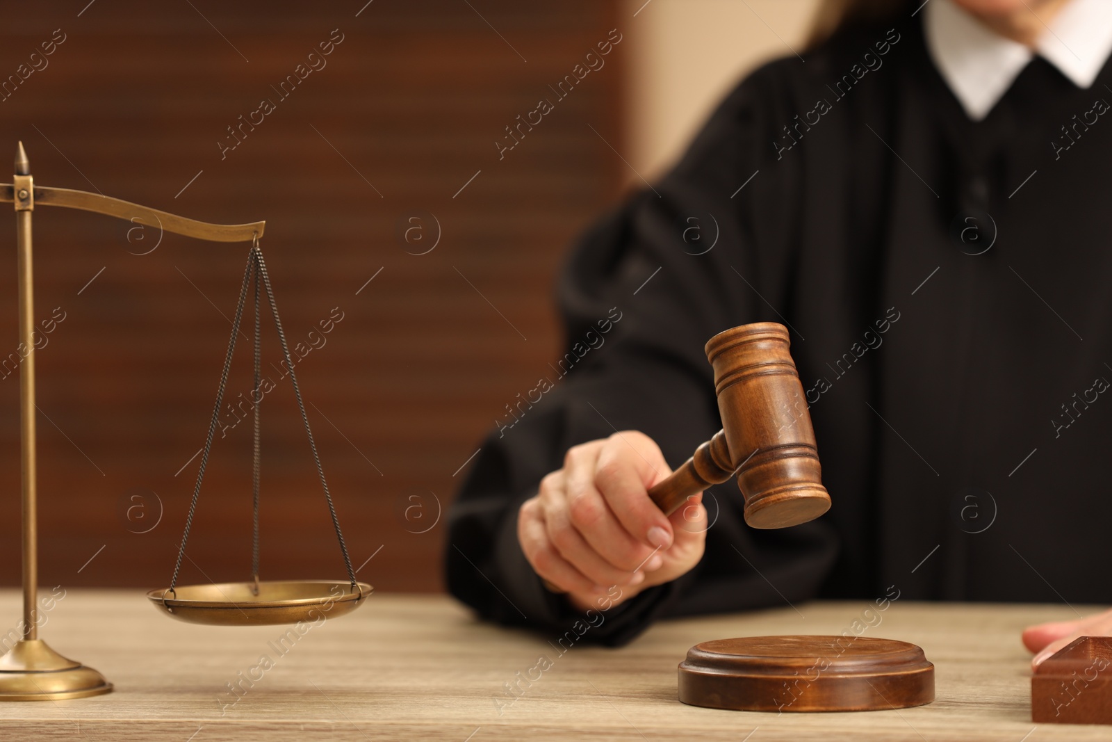 Photo of Judge striking mallet at wooden table indoors, closeup