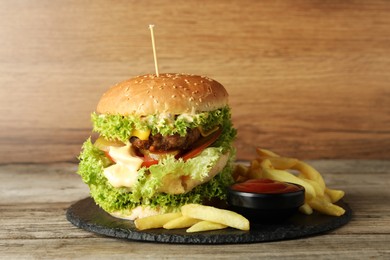 Photo of Burger with delicious patty, french fries and sauce on wooden table