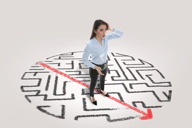 Thoughtful young businesswoman and illustration of maze on light background