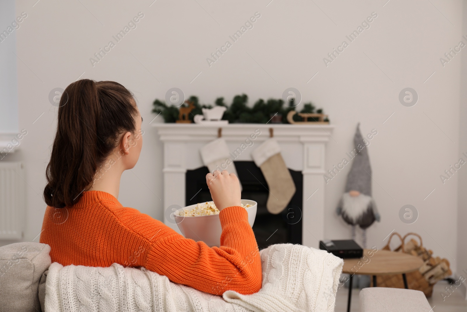 Photo of Woman with popcorn at home. Watching movie via video projector