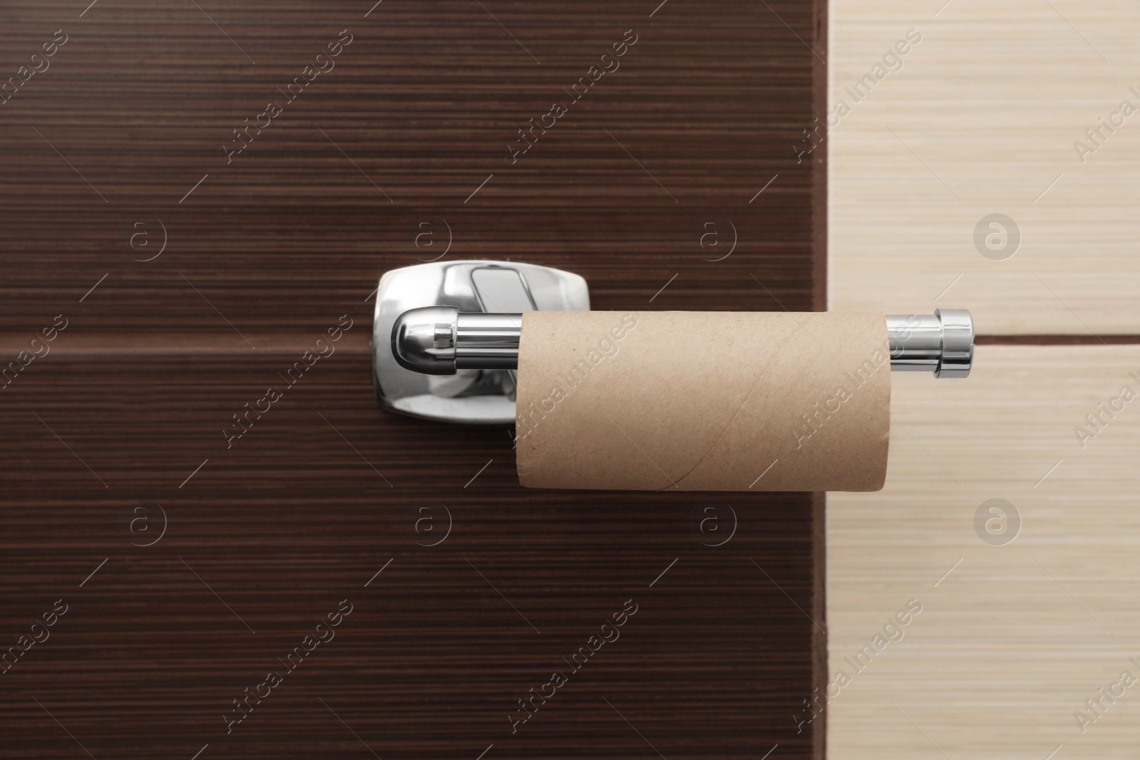 Photo of Holder with empty toilet paper roll in bathroom