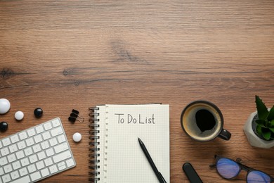 Flat lay composition with unfilled To Do list, cup of coffee and computer keyboard on wooden table, space for text