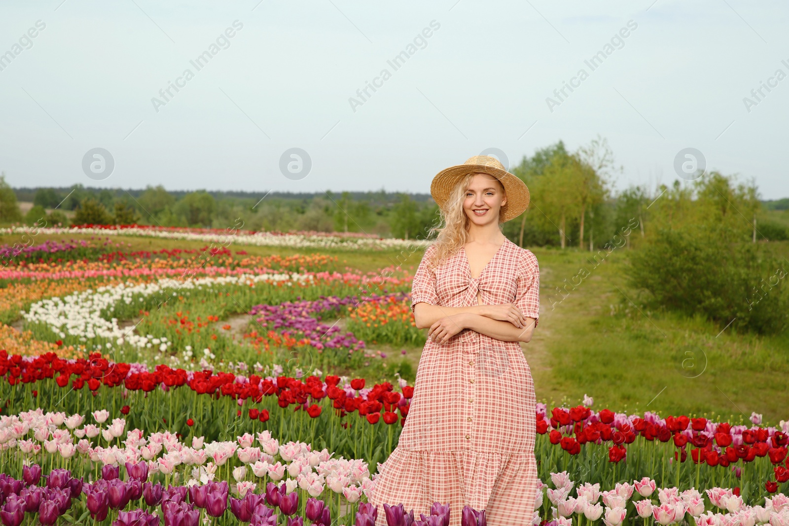 Photo of Happy woman in beautiful tulip field outdoors