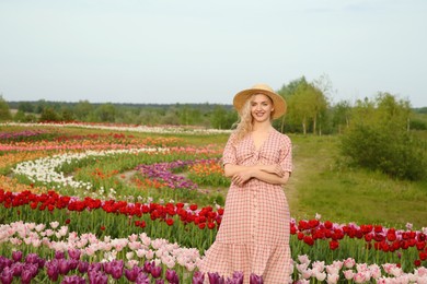 Happy woman in beautiful tulip field outdoors