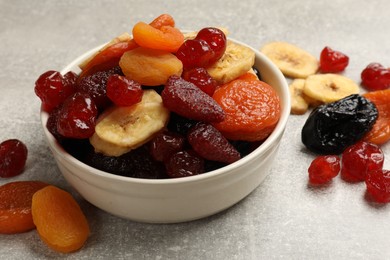 Photo of Mix of delicious dried fruits on grey table, closeup