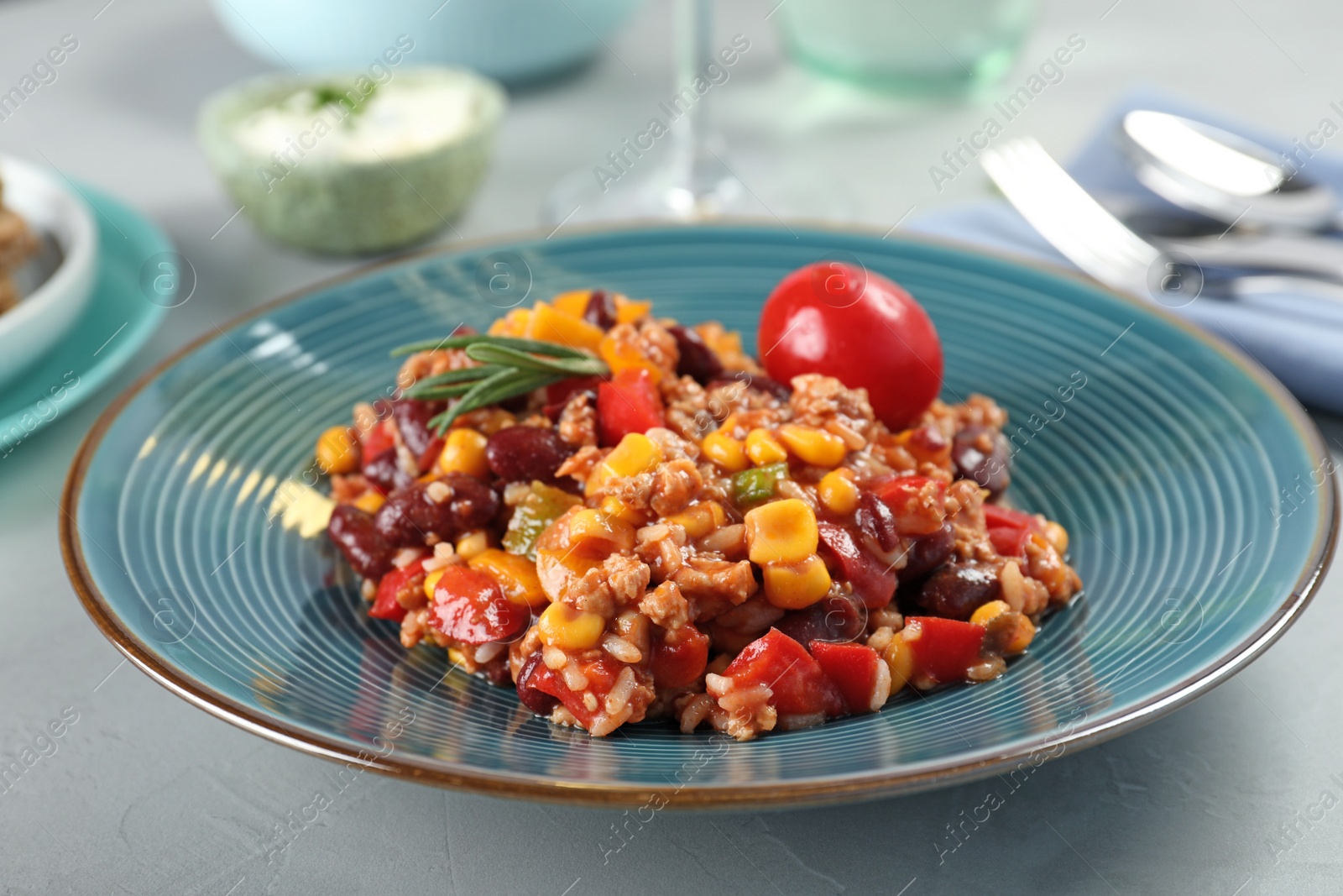 Photo of Plate with tasty chili con carne on gray table