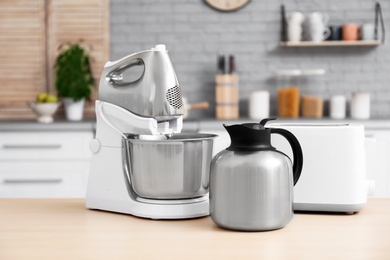 Photo of Different modern kitchen appliances and blurred view of kitchen interior on background