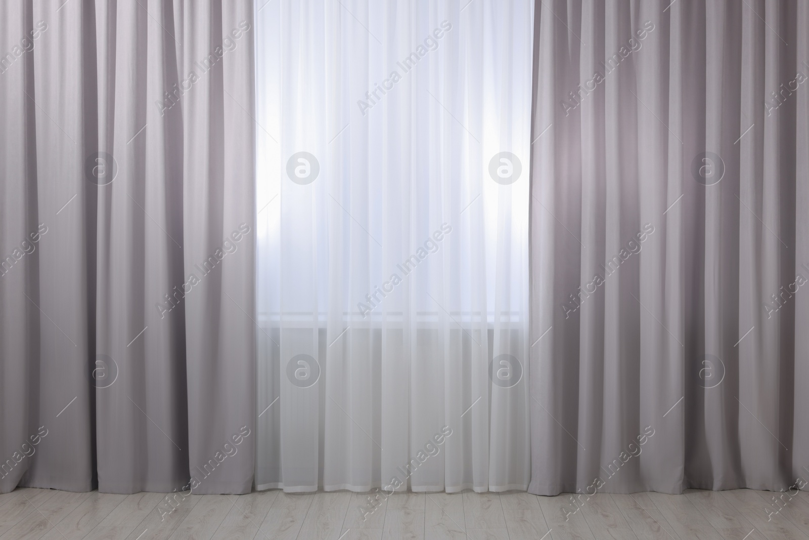 Photo of Light grey window curtains and white tulle indoors