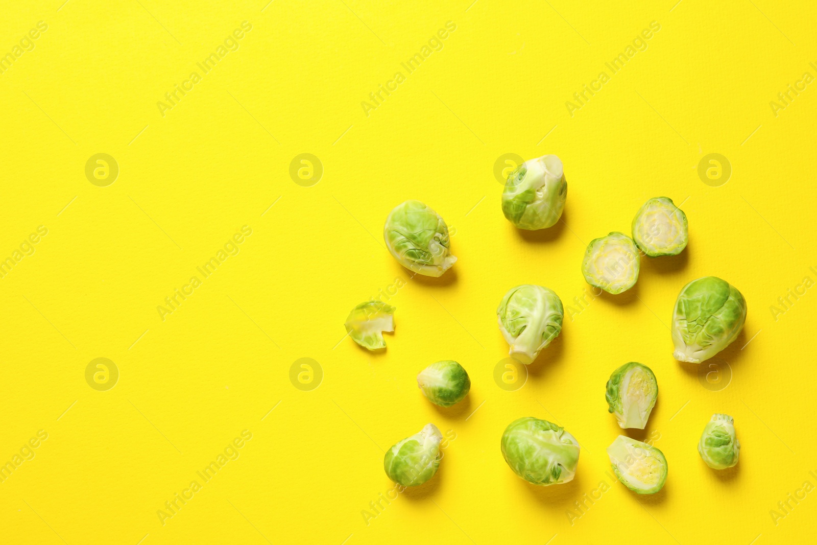 Photo of Fresh Brussels sprouts on color background, flat lay. Space for text