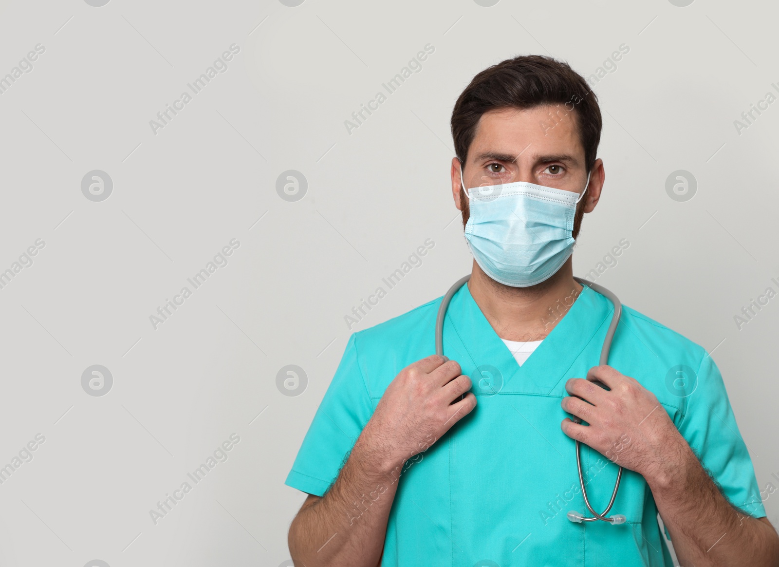 Photo of Nurse with medical mask and stethoscope on white background, space for text