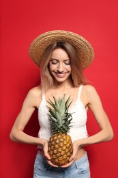 Young woman with fresh pineapple on red background. Exotic fruit