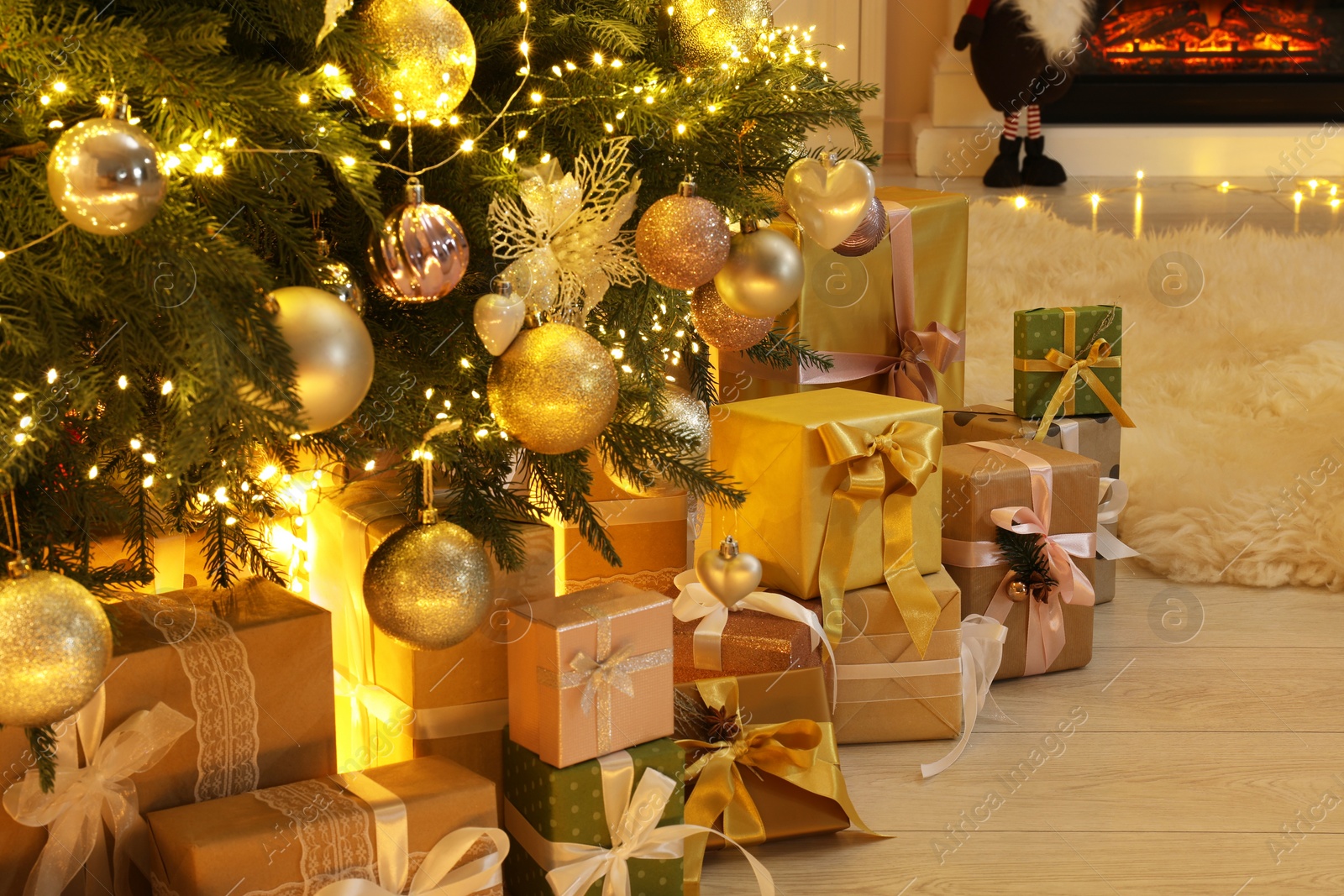 Photo of Many gift boxes under decorated Christmas tree at home