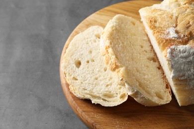 Photo of Freshly baked cut sourdough bread on grey table, closeup. Space for text