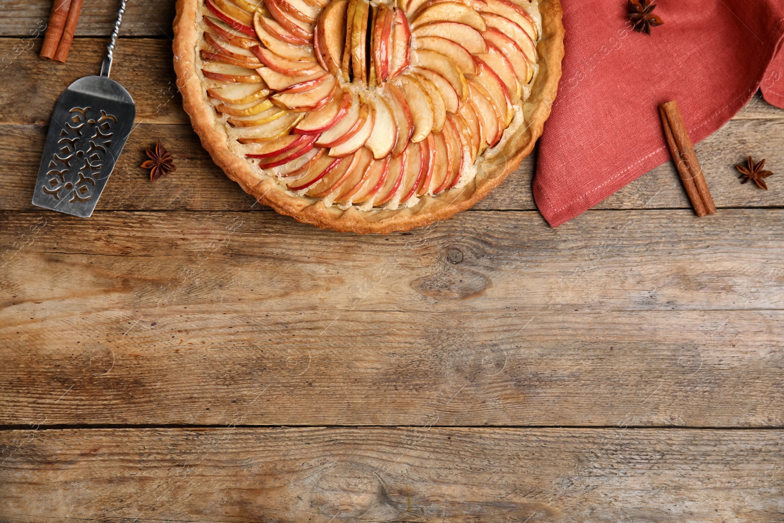 Photo of Flat lay composition with delicious homemade apple tart on wooden table. Space for text