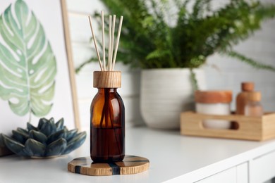 Photo of Air reed freshener on white table indoors, space for text