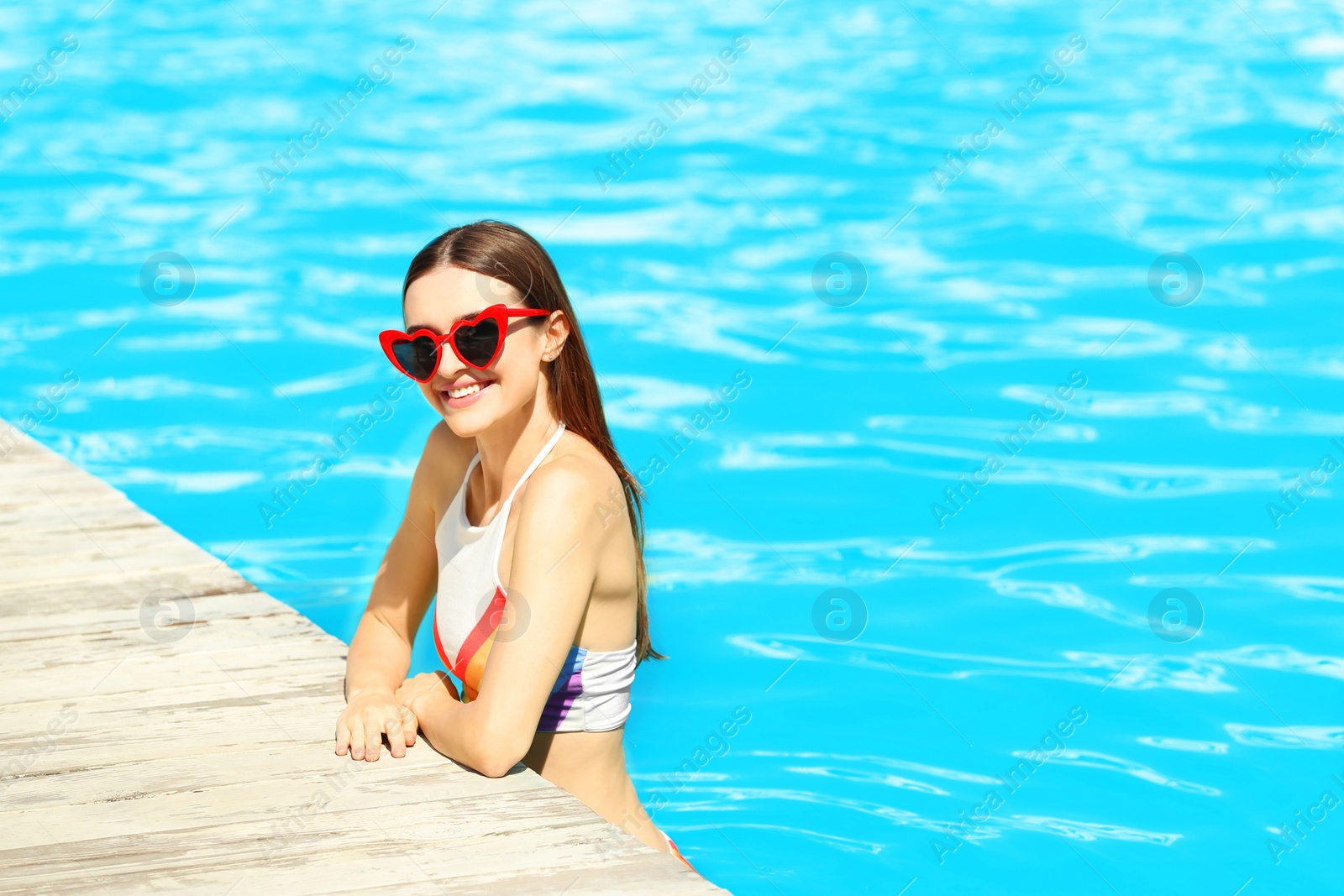 Photo of Beautiful young woman in swimming pool on sunny day