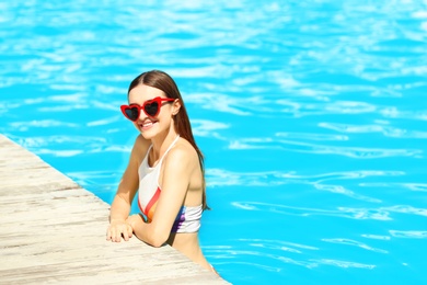 Photo of Beautiful young woman in swimming pool on sunny day