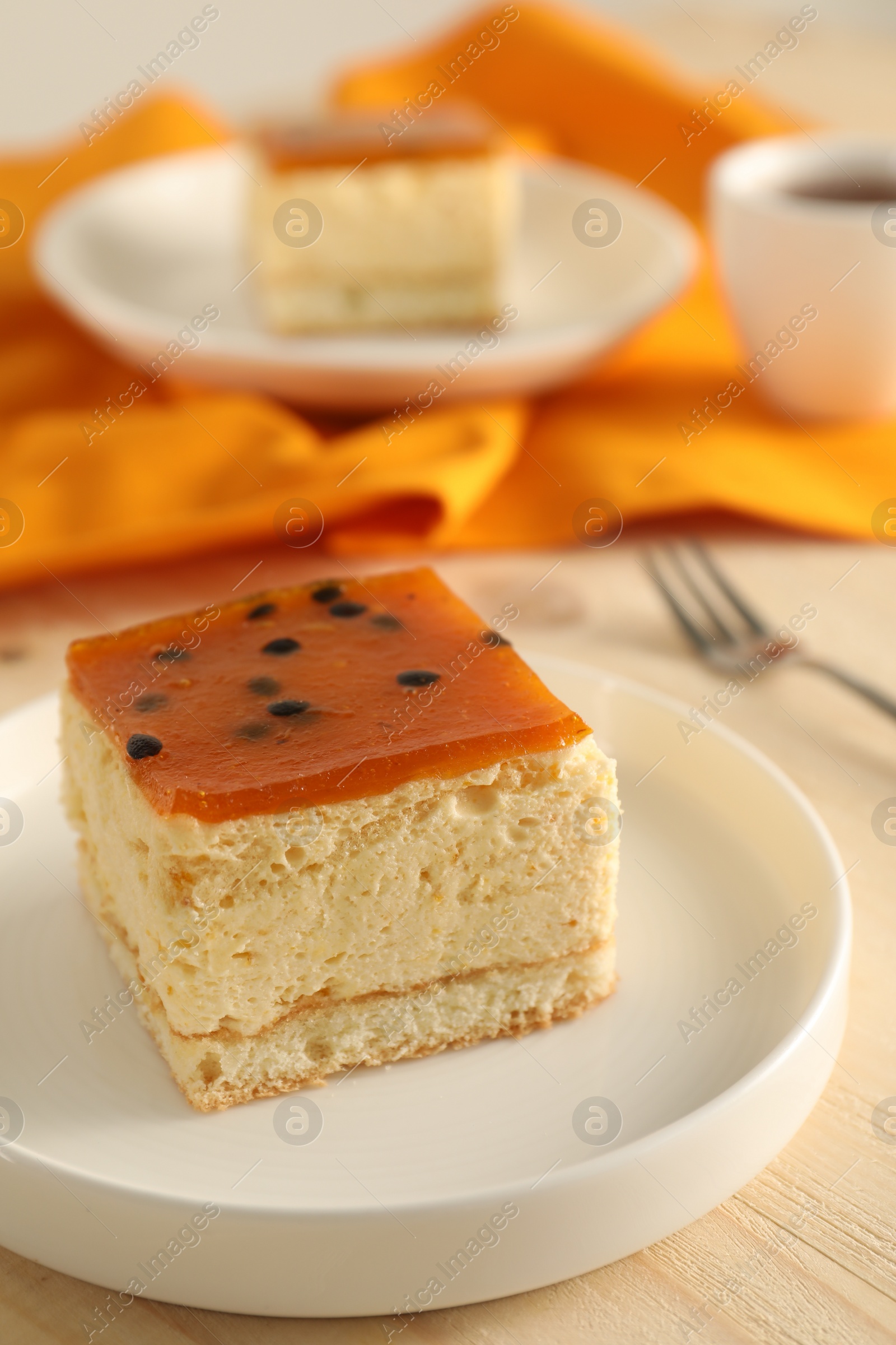 Photo of Piece of cheesecake with jelly on table, closeup