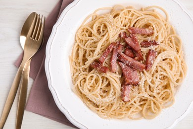 Photo of Delicious Carbonara pasta served on white wooden table, flat lay