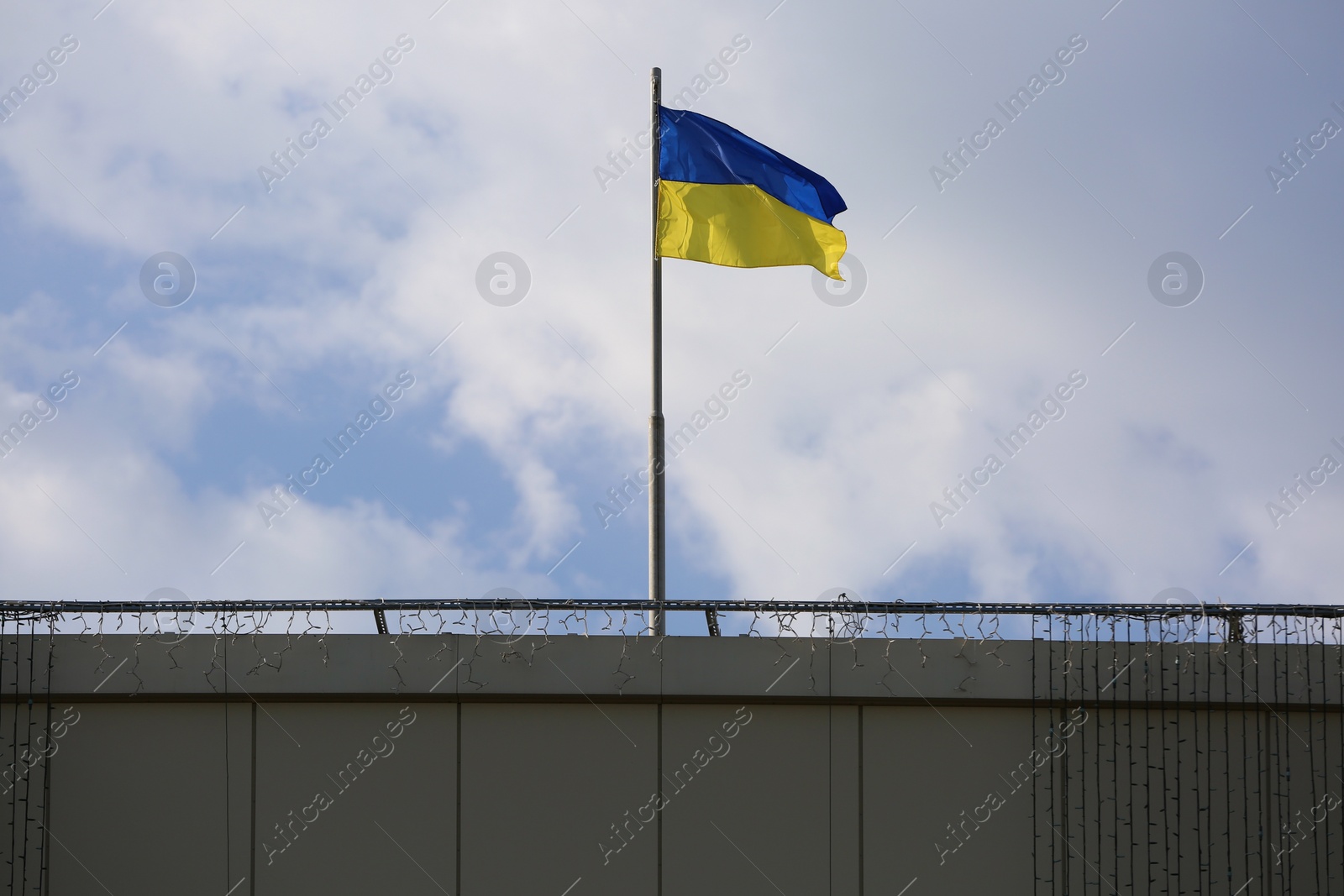 Photo of Ukrainian flag on building against cloudy sky