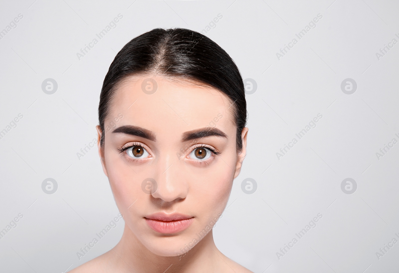 Photo of Beautiful woman with perfect eyebrows on light background