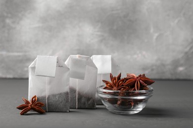 Photo of Tea bags with anise stars on grey table
