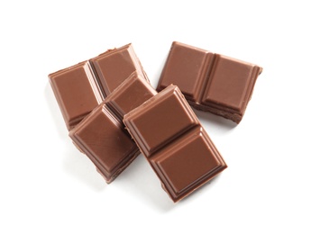 Photo of Pieces of tasty milk chocolate on white background, top view