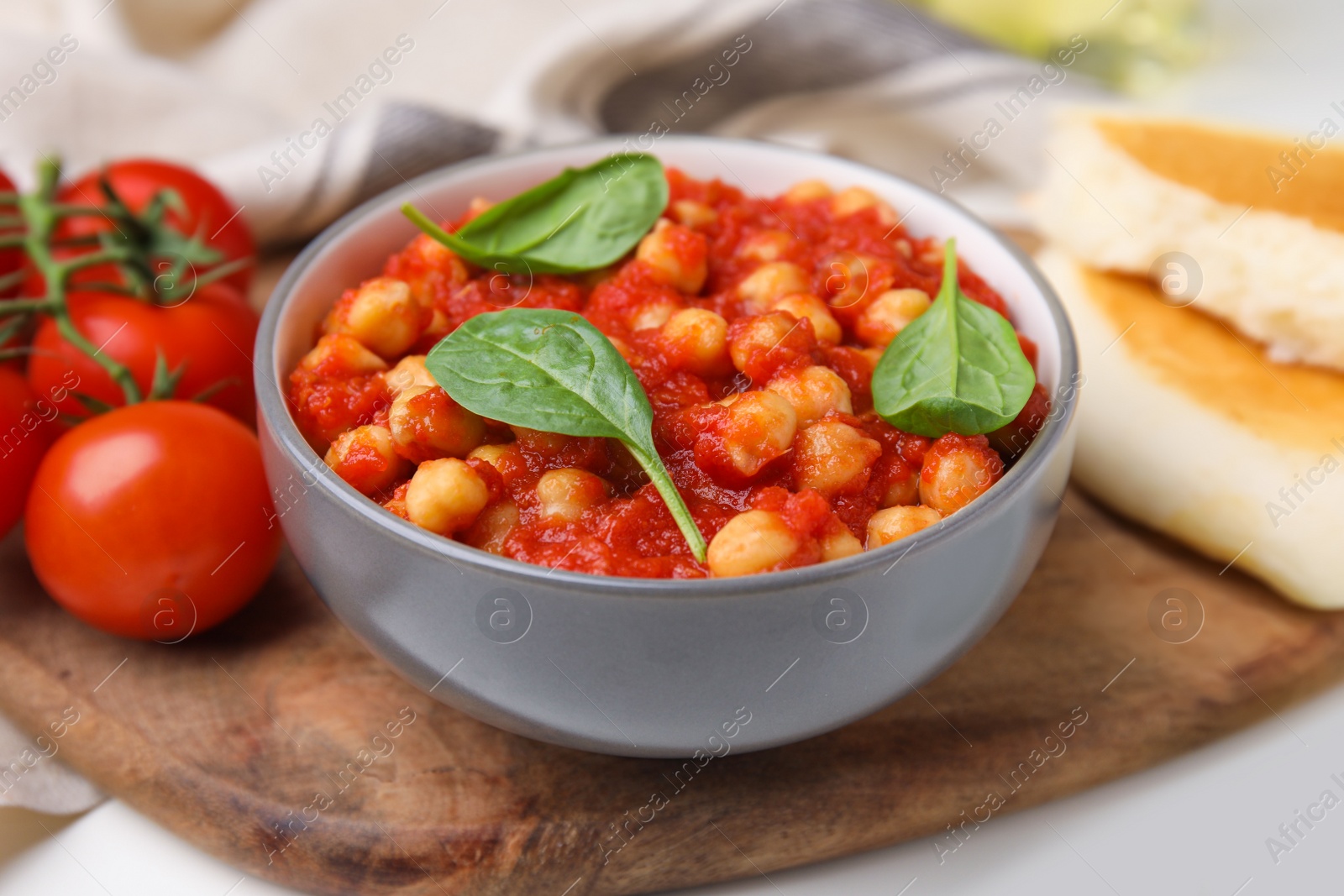 Photo of Delicious chickpea curry served on wooden board, closeup