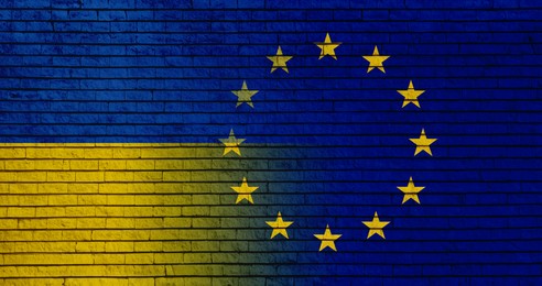 Image of Flags of Ukraine and European Union on brick wall, banner design. International diplomatic relationships