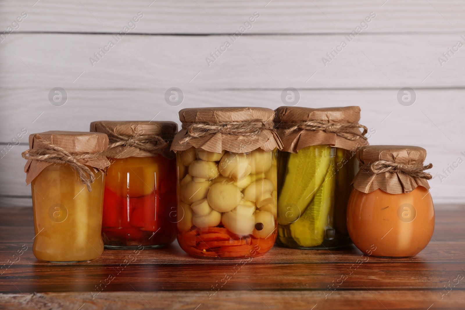 Photo of Many jars with different preserved ingredients on wooden table