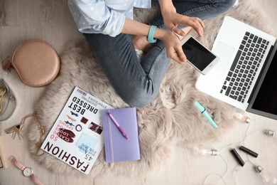 Photo of Female beauty blogger with smartphone and laptop indoors, top view