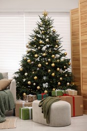 Christmas tree in room decorated for holiday. Festive interior design