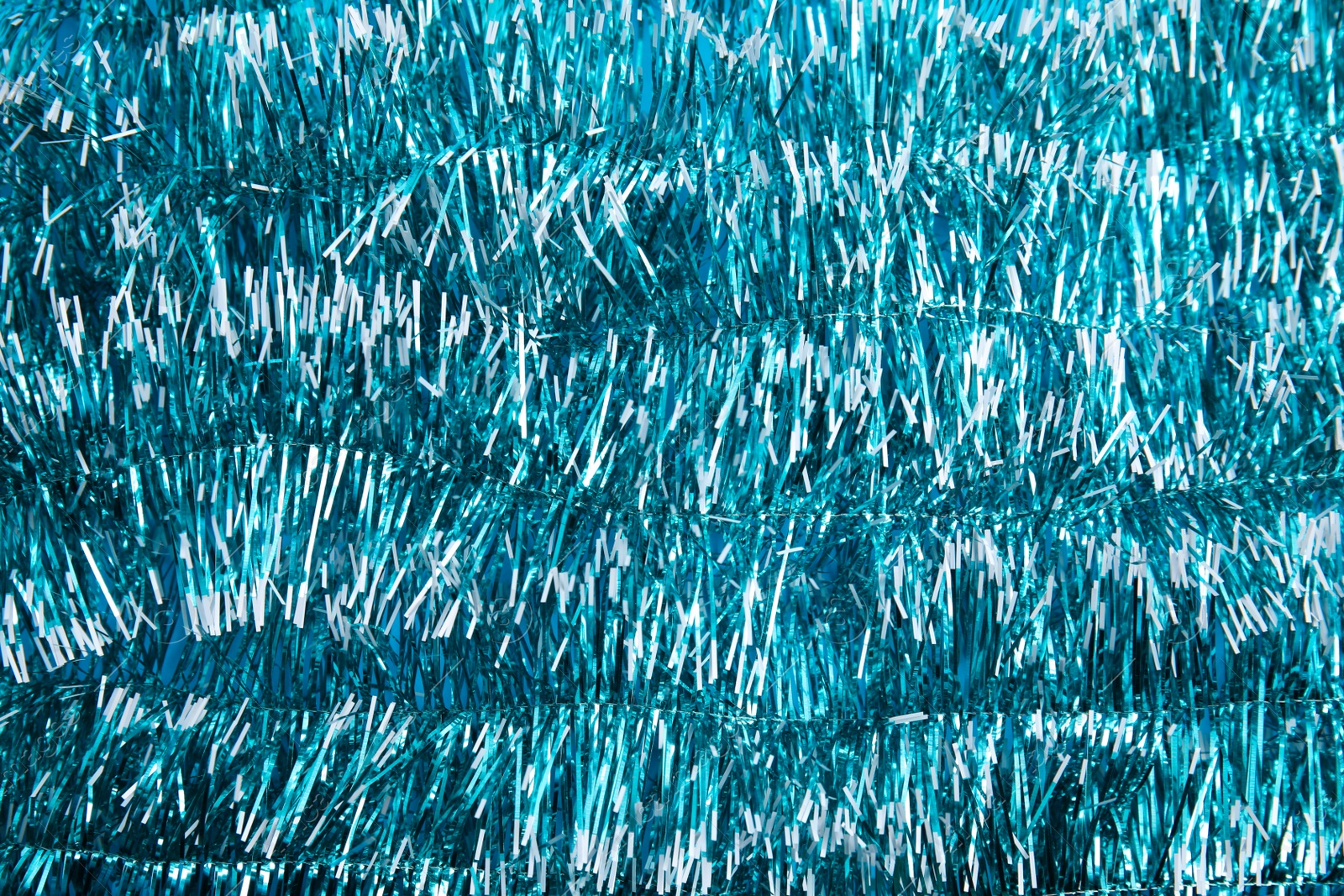 Photo of Light blue tinsel as background. Festive decoration