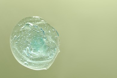 Photo of Sample of cleansing gel on pale green background, top view with space for text. Cosmetic product
