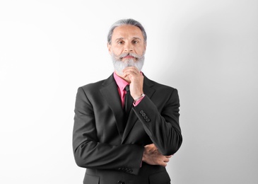 Photo of Handsome bearded mature man in suit on white background